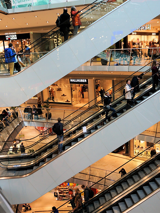 Escalators, shops an customers in a shopping mall