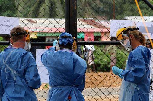 A group of health care workers hang signs on a fence at a field hospital in Monrovia, Liberia, Sept. 19, 2014. The workers are among volunteers from around the world fighting the epidemic outbreak of Ebola.