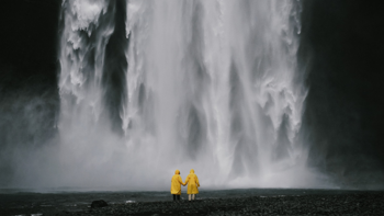 Picture of waterfall, two people in yellow raincoats