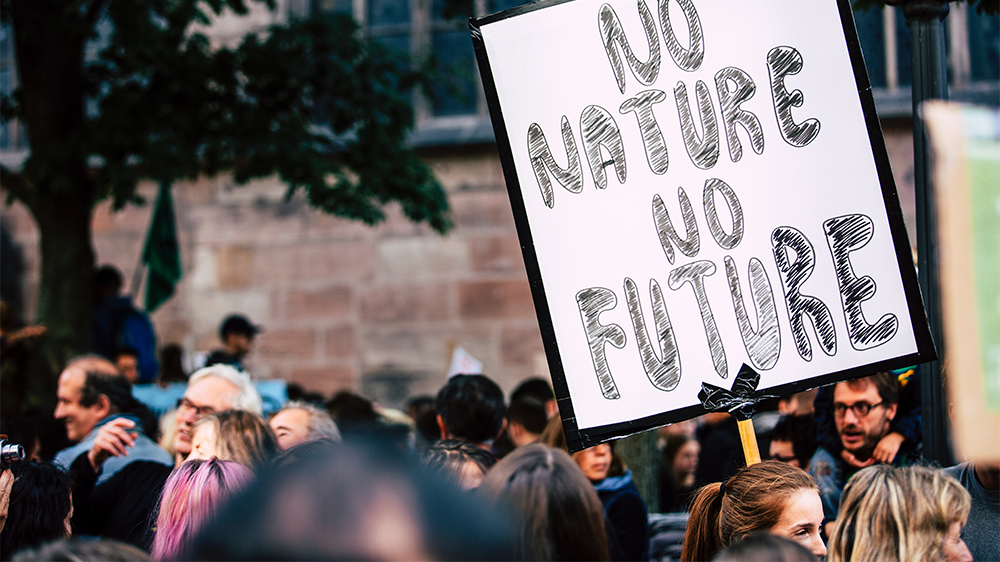 Gatebilde med mennesker og en plakat med teksten: No nature no future