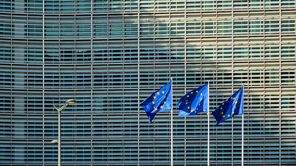 Three EU flags in front of large office building